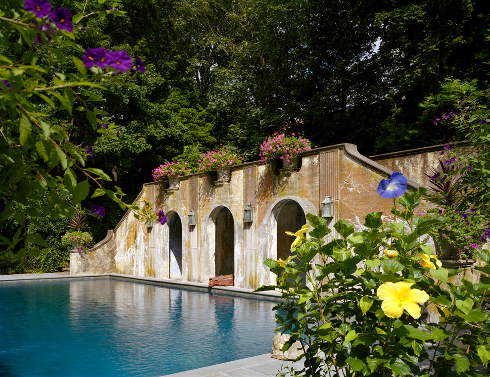 На фото: естественный, прямоугольный бассейн в средиземноморском стиле с домиком у бассейна и мощением тротуарной плиткой с