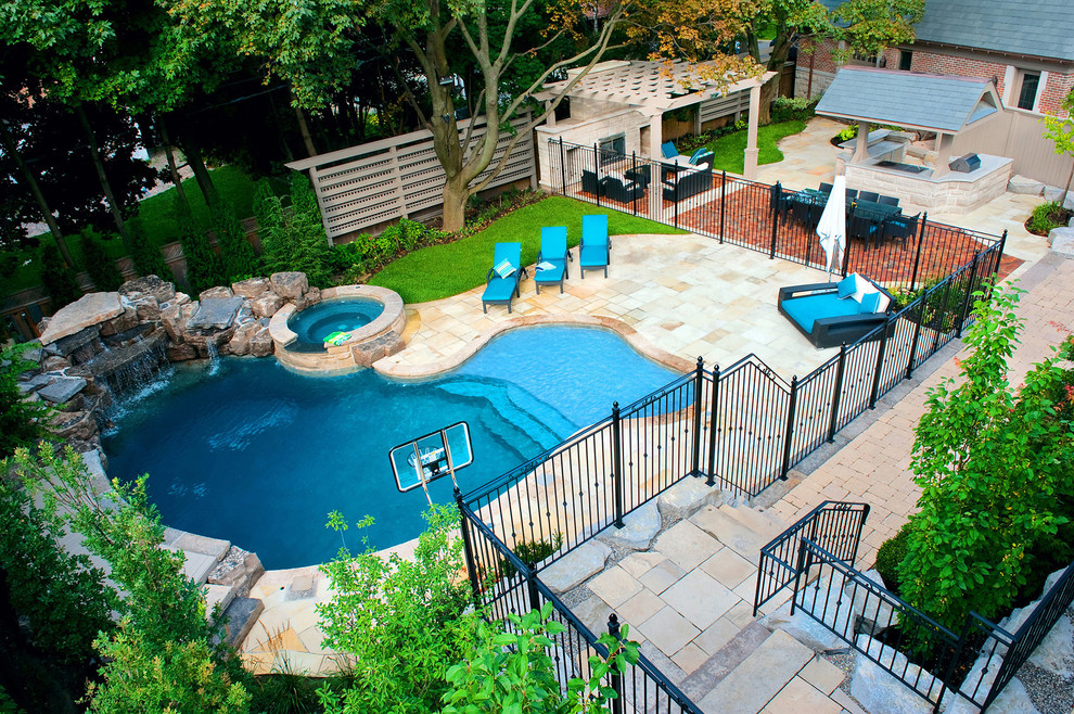 Modelo de piscina con fuente clásica grande a medida en patio trasero con adoquines de piedra natural