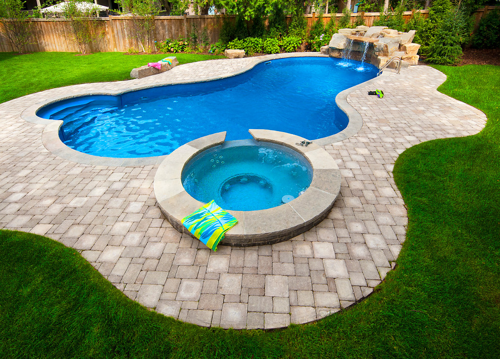 Стильный дизайн: бассейн среднего размера на заднем дворе в классическом стиле с джакузи и мощением тротуарной плиткой - последний тренд