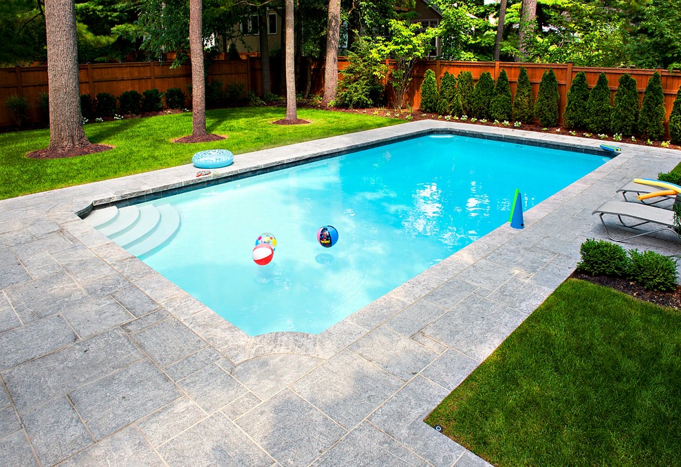 Inspiration for a large traditional rectangular swimming pool in Toronto with natural stone paving.