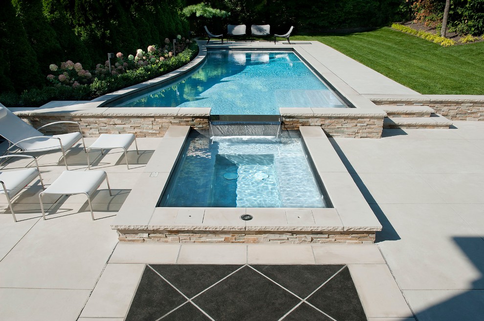 Diseño de piscina infinita clásica de tamaño medio a medida en patio trasero con adoquines de piedra natural