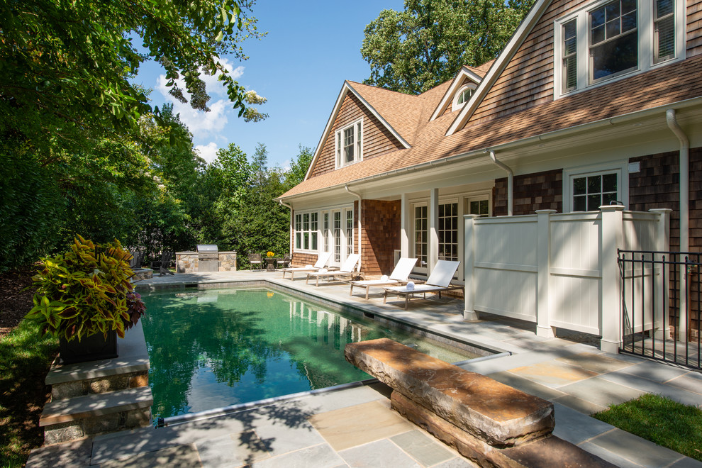 Esempio di una grande piscina naturale stile marinaro rettangolare dietro casa con fontane e pavimentazioni in pietra naturale