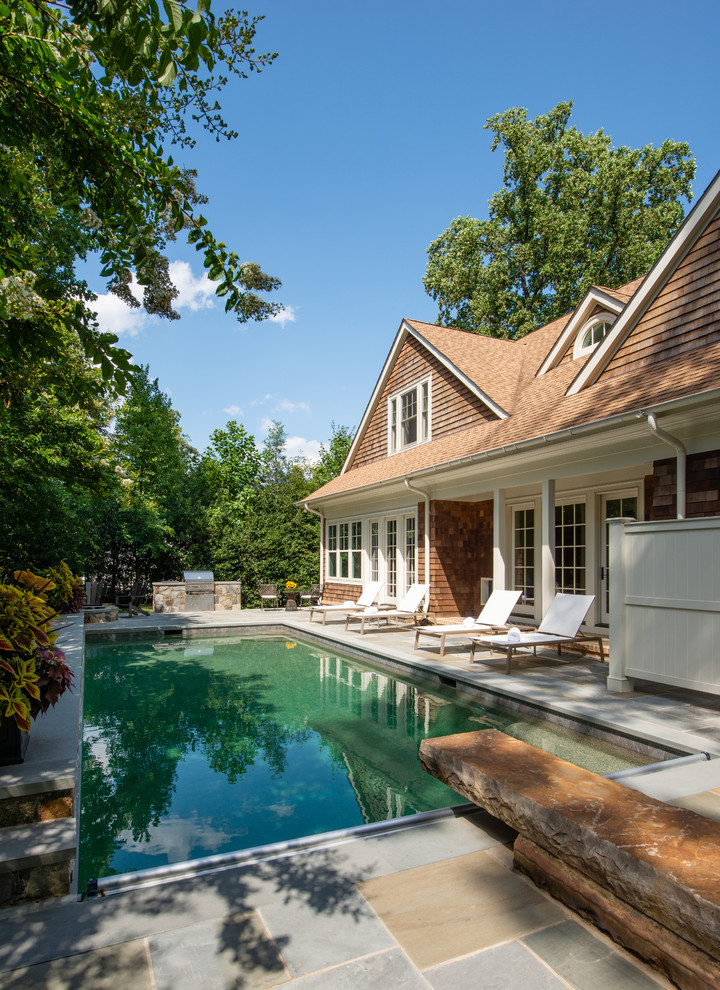 Foto de piscina con fuente natural costera grande rectangular en patio trasero con adoquines de piedra natural