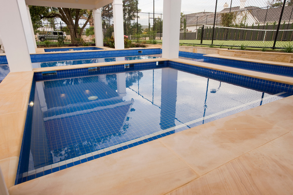 Idee per una grande piscina classica personalizzata dietro casa con una vasca idromassaggio e pavimentazioni in pietra naturale