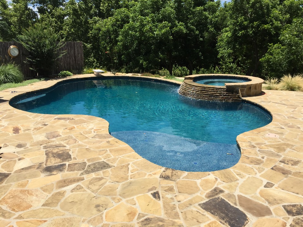 На фото: естественный бассейн среднего размера, произвольной формы на заднем дворе в классическом стиле с джакузи и покрытием из каменной брусчатки с
