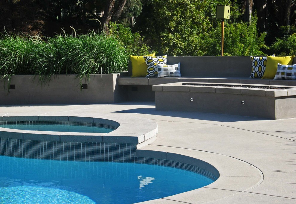 Aménagement d'une piscine arrière et naturelle contemporaine en forme de haricot de taille moyenne avec une dalle de béton.