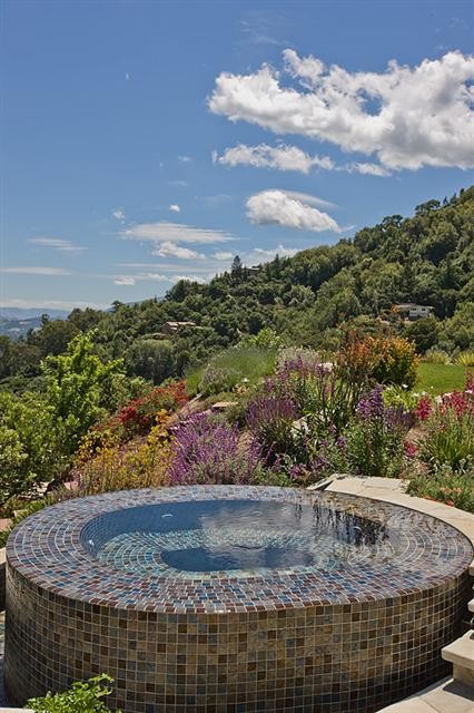 Inspiration for a mid-sized mediterranean backyard stone and custom-shaped infinity hot tub remodel in San Francisco
