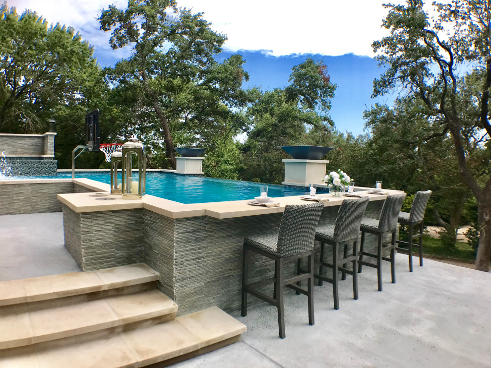 Immagine di una grande piscina a sfioro infinito contemporanea rettangolare dietro casa con una vasca idromassaggio e pedane