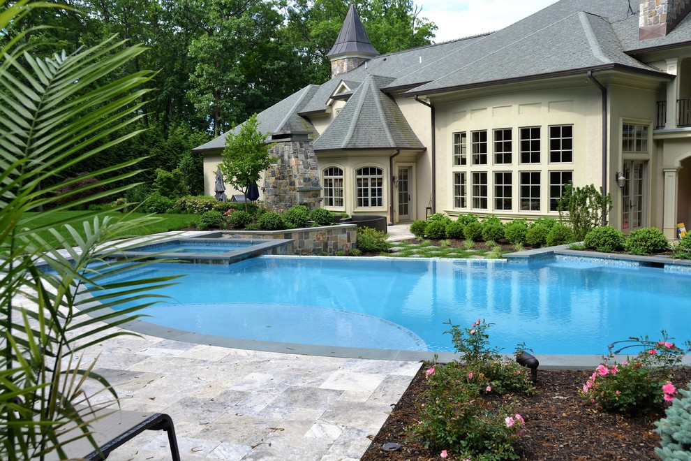 Esempio di una grande piscina moderna personalizzata dietro casa con pavimentazioni in pietra naturale