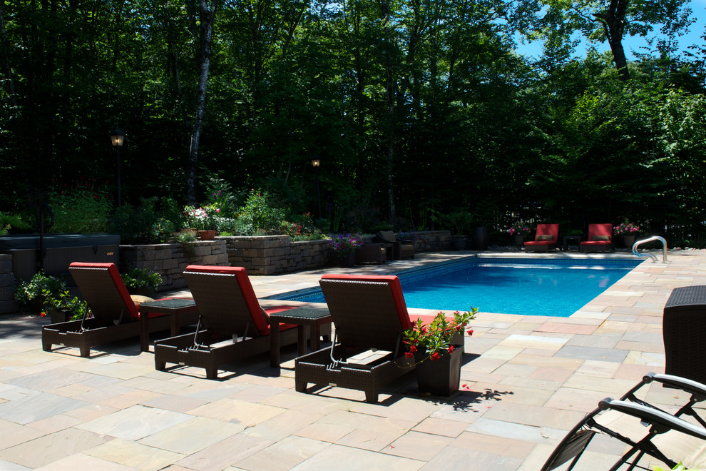 Modelo de piscinas y jacuzzis clásicos grandes rectangulares en patio trasero con adoquines de ladrillo