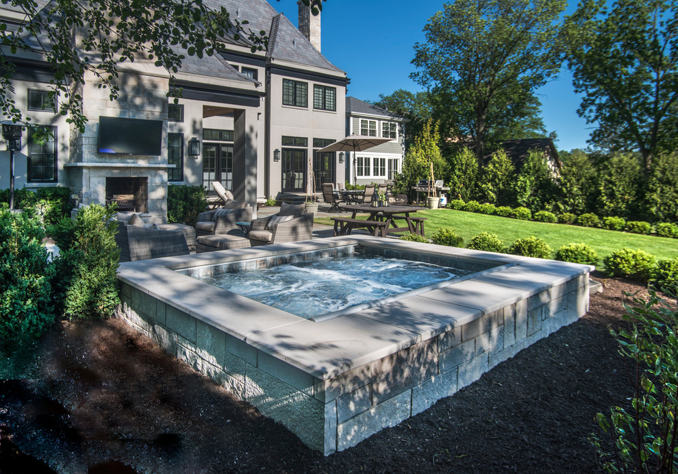 Esempio di una piccola piscina naturale classica rettangolare dietro casa con una vasca idromassaggio e pavimentazioni in pietra naturale