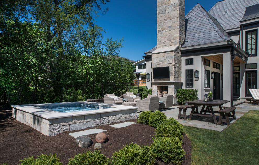 Foto di una piccola piscina naturale classica rettangolare dietro casa con una vasca idromassaggio e pavimentazioni in pietra naturale