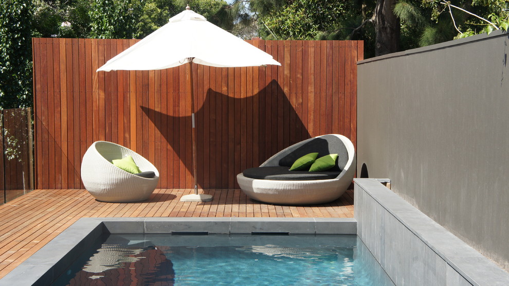 Modelo de piscina alargada contemporánea de tamaño medio rectangular en patio con entablado