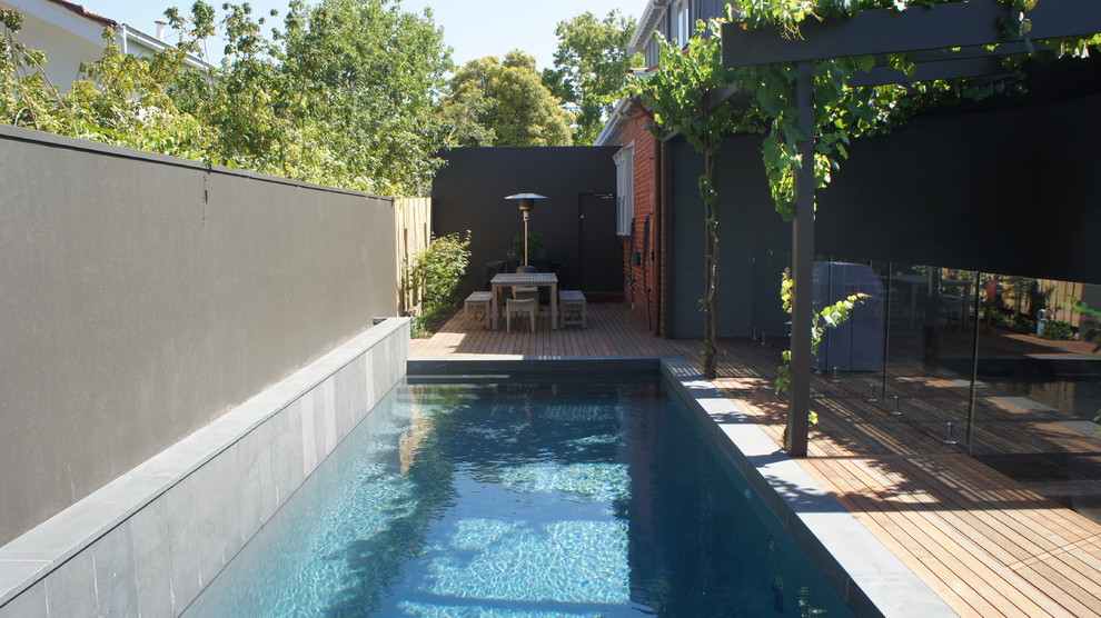 Inspiration for a mid-sized contemporary courtyard rectangular lap pool remodel in Melbourne with decking