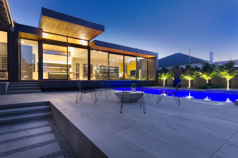 Inspiration for a large contemporary back rectangular swimming pool in Melbourne with concrete paving.