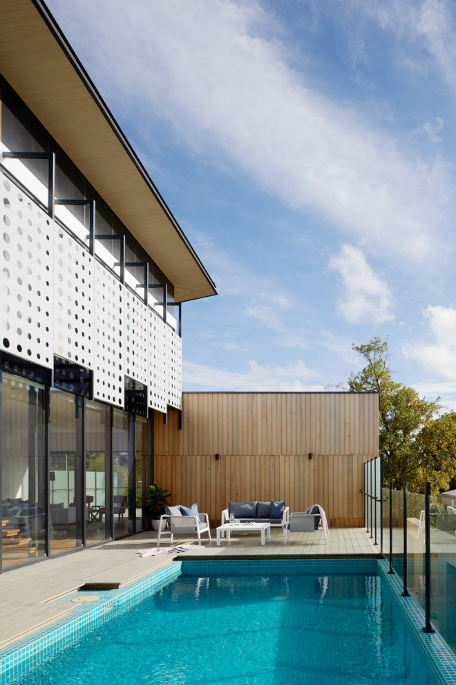 Exemple d'un grand Abris de piscine et pool houses latéral tendance rectangle avec une terrasse en bois.