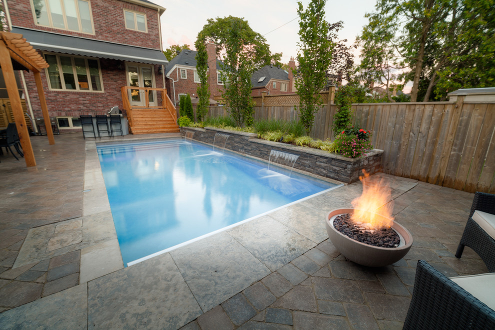 Foto di una piscina classica rettangolare di medie dimensioni e dietro casa con fontane e pavimentazioni in mattoni