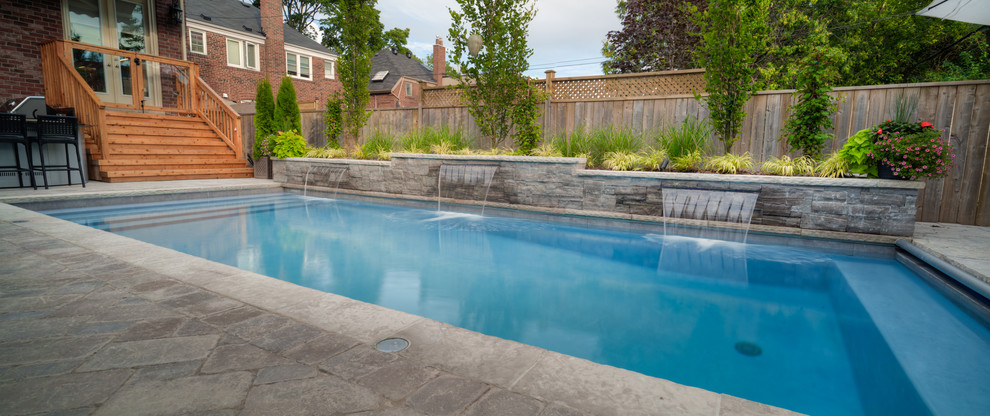 Пример оригинального дизайна: прямоугольный бассейн среднего размера на заднем дворе в классическом стиле с фонтаном и мощением клинкерной брусчаткой