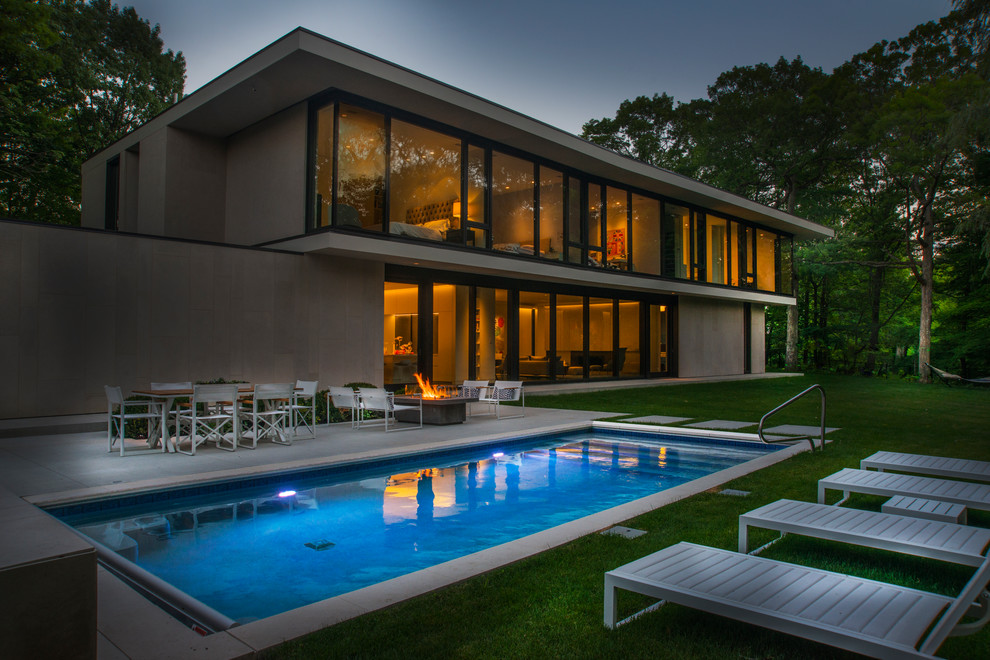 Imagen de piscina alargada moderna pequeña rectangular en patio trasero con adoquines de piedra natural