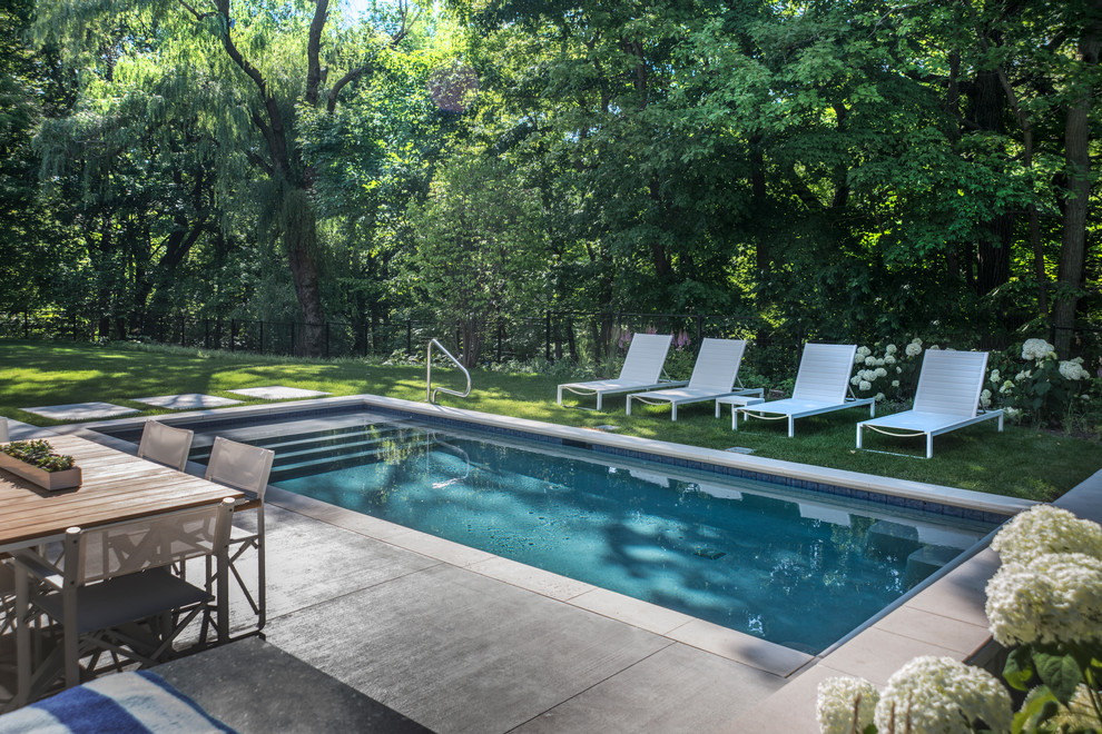 Imagen de piscina alargada moderna pequeña rectangular en patio trasero con adoquines de piedra natural