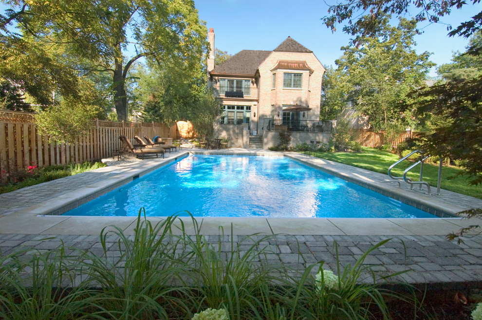 Immagine di una piscina monocorsia classica rettangolare di medie dimensioni e dietro casa con pavimentazioni in cemento