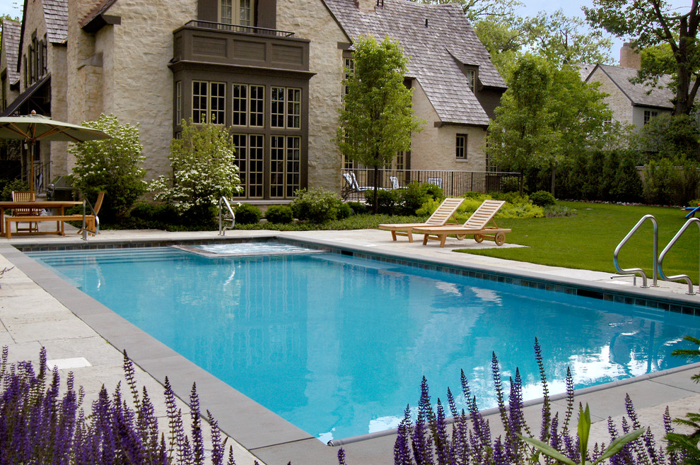 Foto di una piscina monocorsia classica rettangolare di medie dimensioni e dietro casa con una vasca idromassaggio e pavimentazioni in cemento