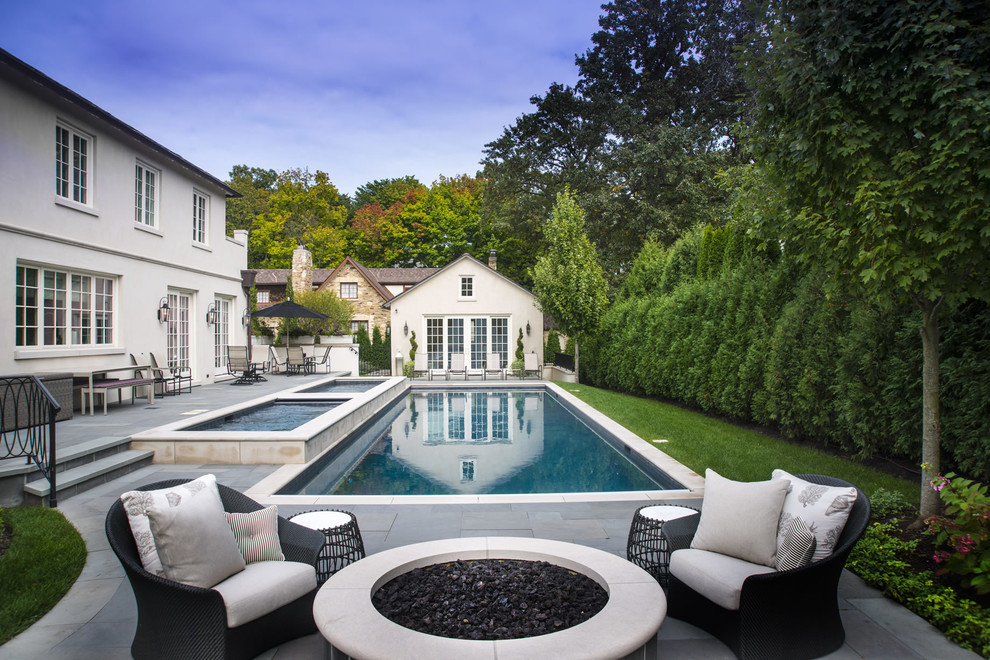 Ejemplo de casa de la piscina y piscina tradicional de tamaño medio rectangular en patio trasero con adoquines de hormigón