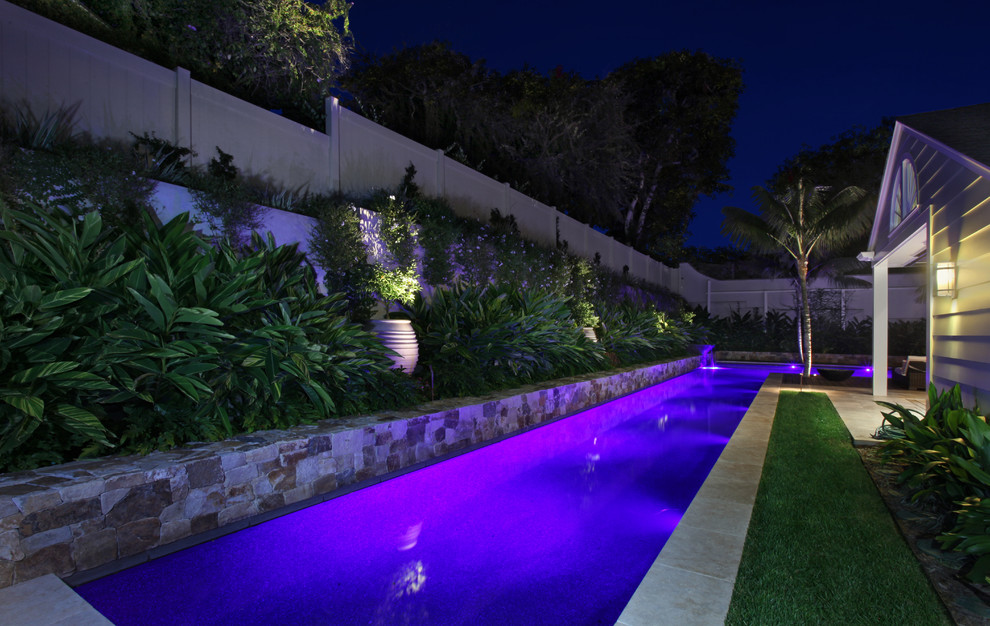 Ejemplo de piscina con fuente alargada contemporánea extra grande a medida en patio trasero con suelo de baldosas