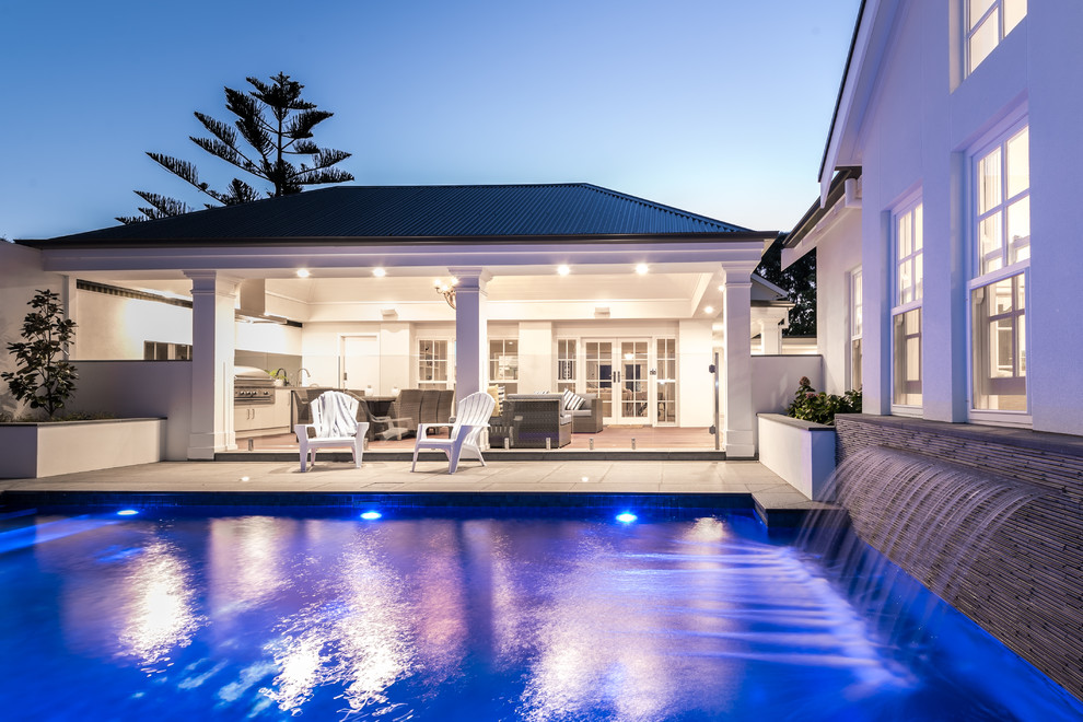 Large traditional back rectangular swimming pool in Adelaide with a water feature and tiled flooring.