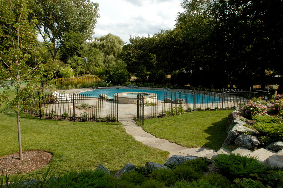 Modelo de piscinas y jacuzzis naturales rurales grandes en patio trasero con adoquines de piedra natural