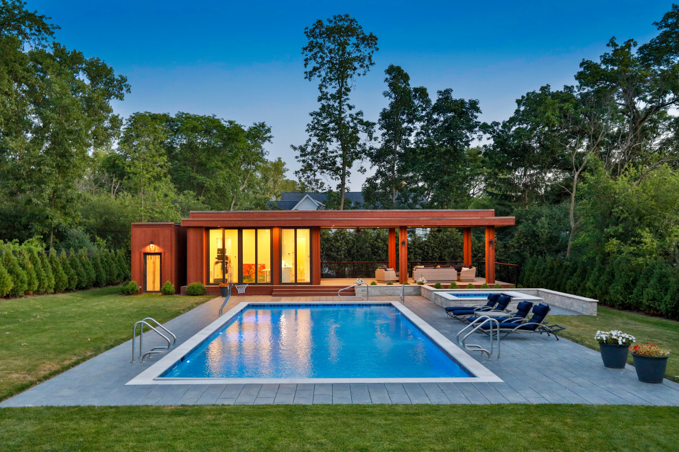 Immagine di una piscina monocorsia chic rettangolare di medie dimensioni e dietro casa con una vasca idromassaggio e pavimentazioni in cemento