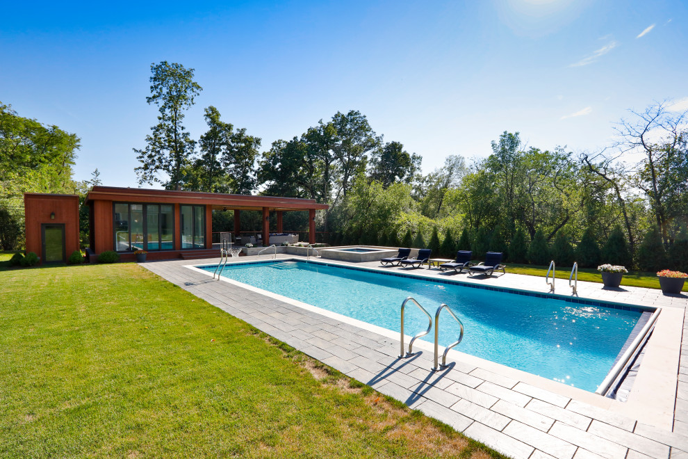 Esempio di una piscina monocorsia classica rettangolare di medie dimensioni e dietro casa con una vasca idromassaggio e pavimentazioni in cemento