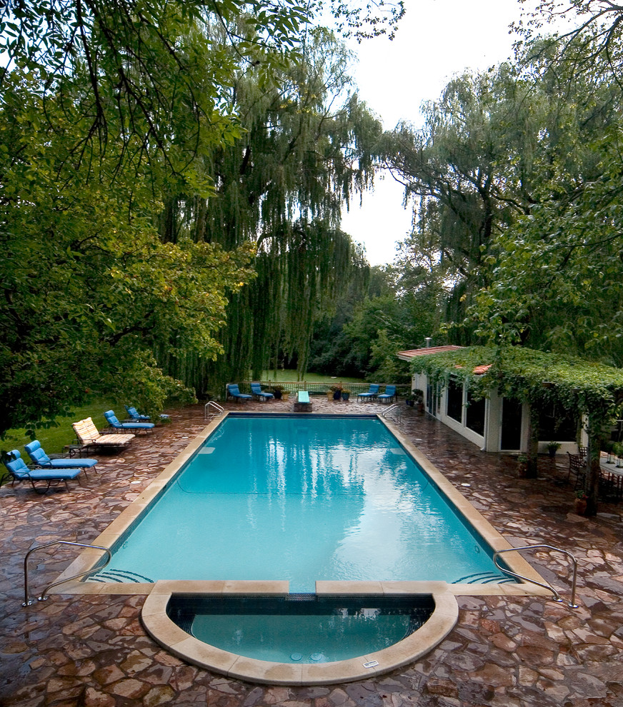 На фото: большой прямоугольный, спортивный бассейн на заднем дворе в классическом стиле с джакузи и покрытием из каменной брусчатки с