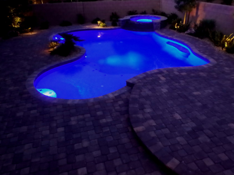 Inspiration for a medium sized mediterranean back custom shaped swimming pool in Las Vegas with brick paving.