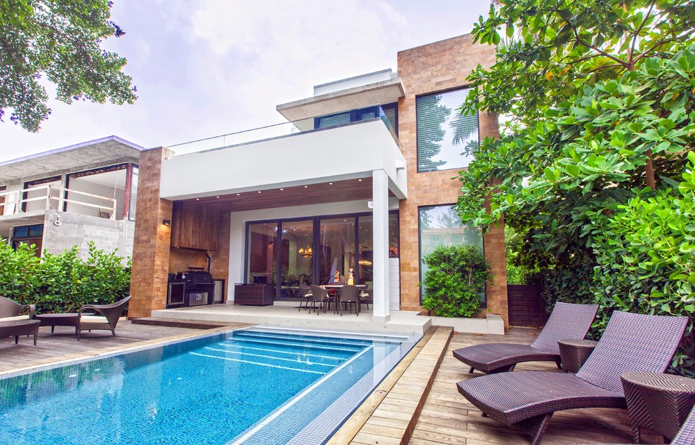 Esempio di una piscina naturale design rettangolare di medie dimensioni e dietro casa con pedane