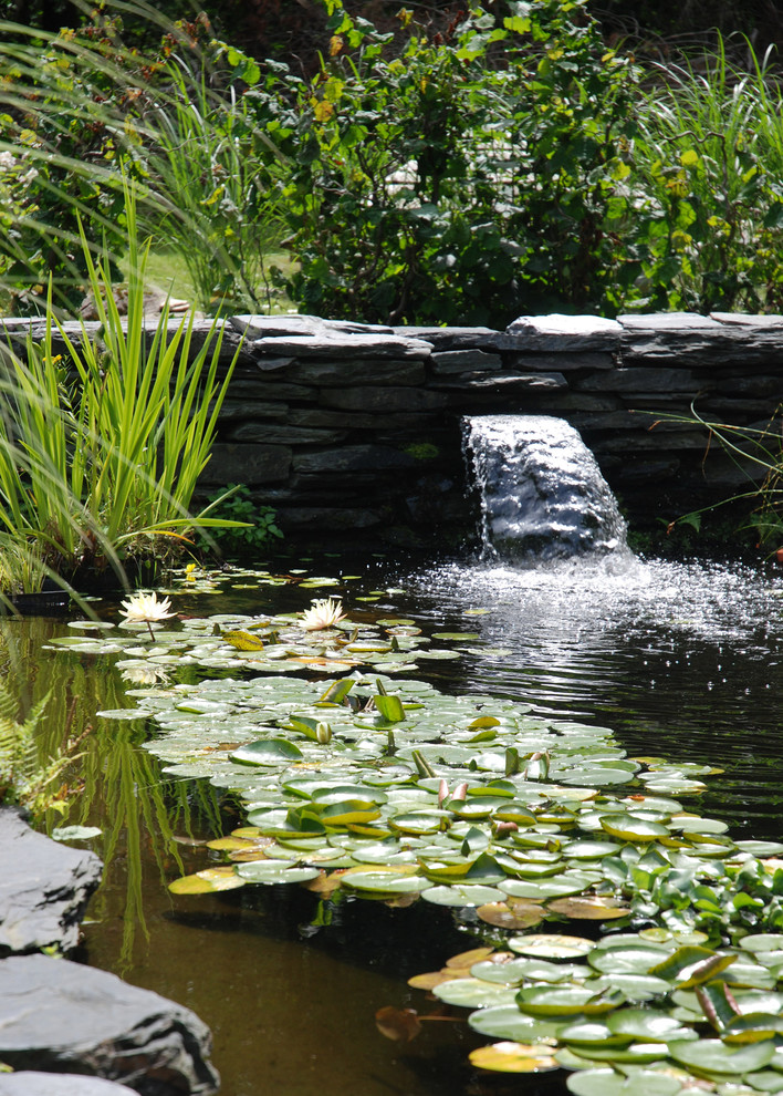 Mittelgroßer Klassischer Garten hinter dem Haus mit Wasserspiel und Natursteinplatten in Montreal