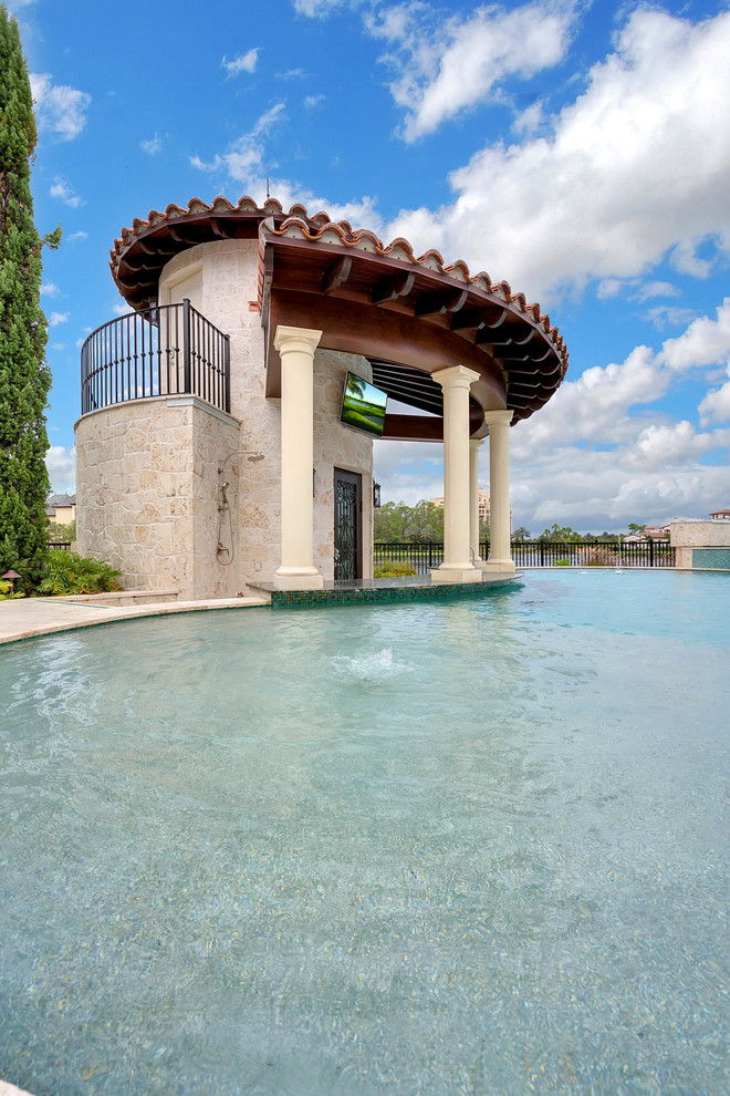 На фото: большой бассейн произвольной формы на заднем дворе в стиле неоклассика (современная классика) с домиком у бассейна и покрытием из каменной брусчатки