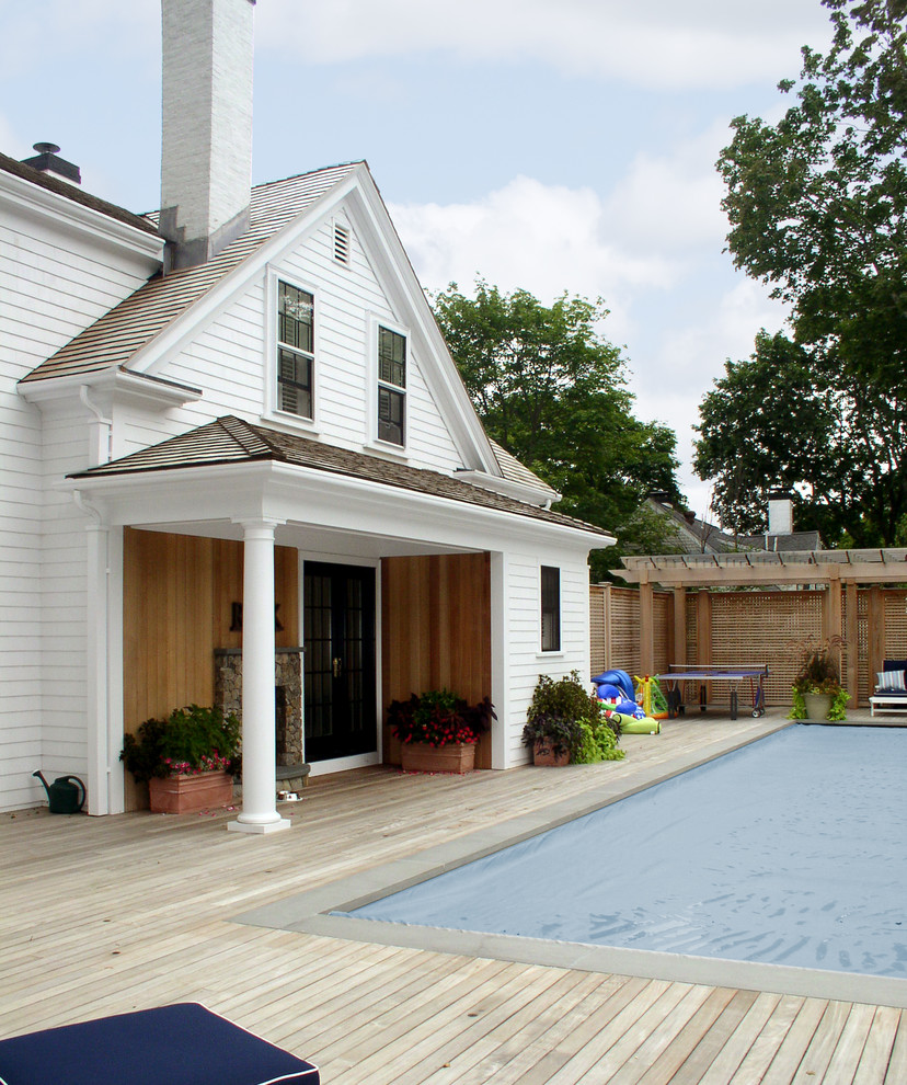 Mid-sized transitional backyard rectangular pool photo in Boston with decking