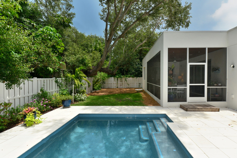Foto de piscina moderna de tamaño medio rectangular en patio trasero con adoquines de hormigón