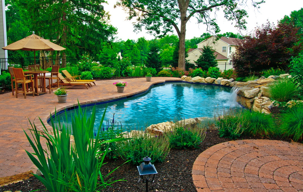 Foto di una grande piscina stile rurale personalizzata dietro casa con pavimentazioni in cemento