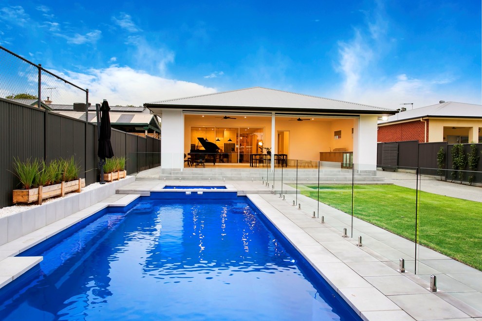 Ejemplo de piscinas y jacuzzis alargados contemporáneos extra grandes rectangulares en patio trasero con adoquines de piedra natural
