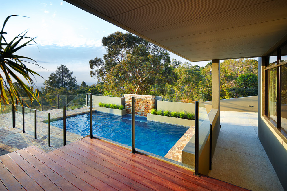 Aménagement d'une piscine sur toit rétro de taille moyenne et rectangle avec des pavés en pierre naturelle.