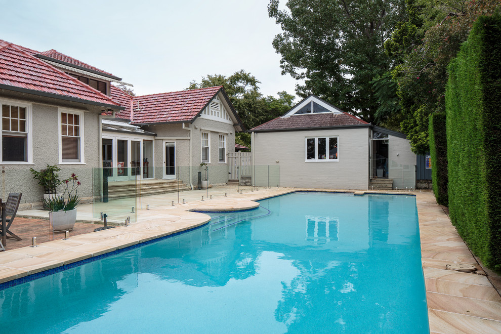 Foto di un'ampia piscina monocorsia chic rettangolare dietro casa con pavimentazioni in pietra naturale
