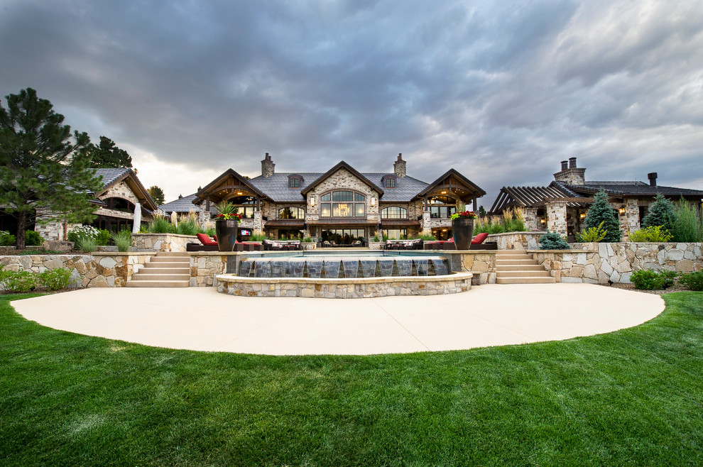 Geräumiger Rustikaler Infinity-Pool hinter dem Haus in rechteckiger Form mit Wasserspiel und Betonboden in Denver
