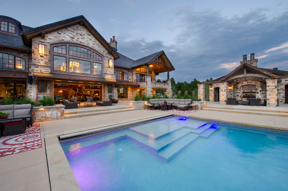 Diseño de casa de la piscina y piscina infinita rural extra grande rectangular en patio trasero con adoquines de hormigón