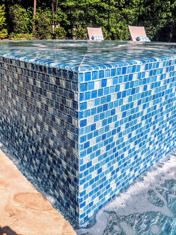 Ispirazione per una grande piscina monocorsia classica personalizzata dietro casa con una vasca idromassaggio e pavimentazioni in cemento