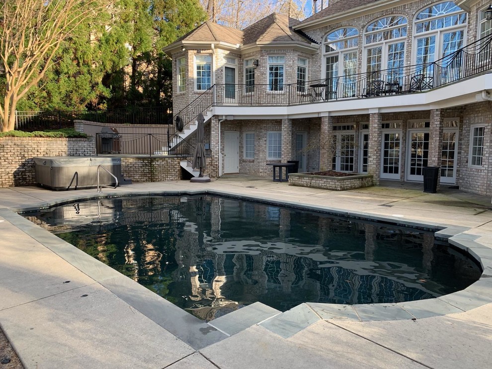 Inspiration for a medium sized modern back custom shaped lengths swimming pool in Raleigh with a pool house and concrete slabs.
