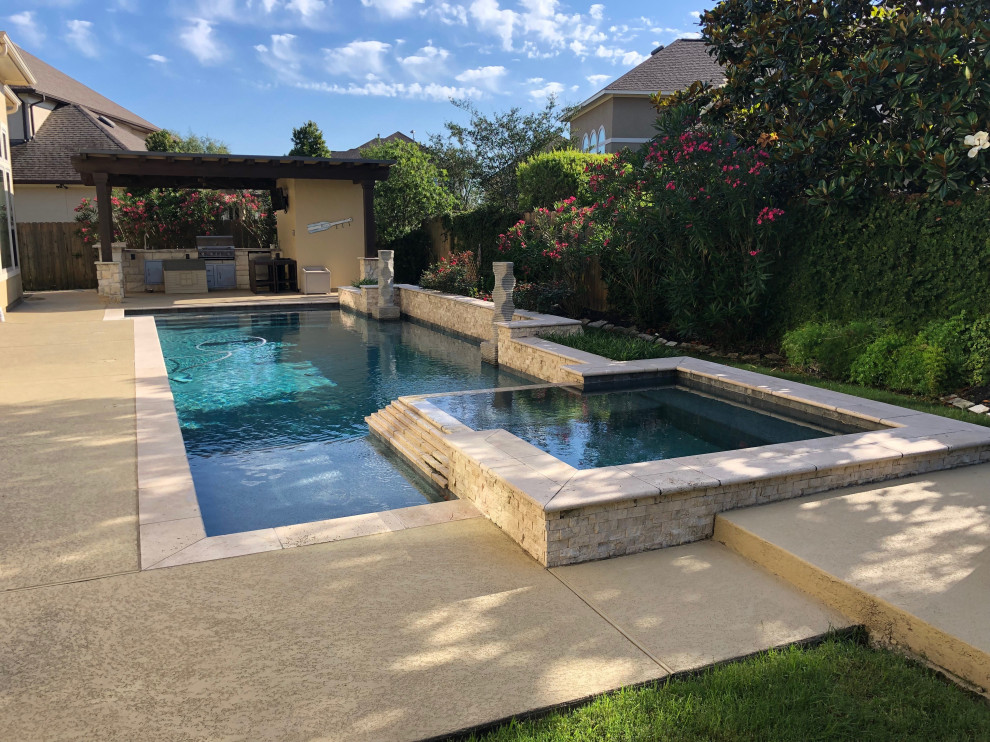 Modelo de casa de la piscina y piscina alargada tradicional de tamaño medio rectangular en patio trasero con adoquines de piedra natural