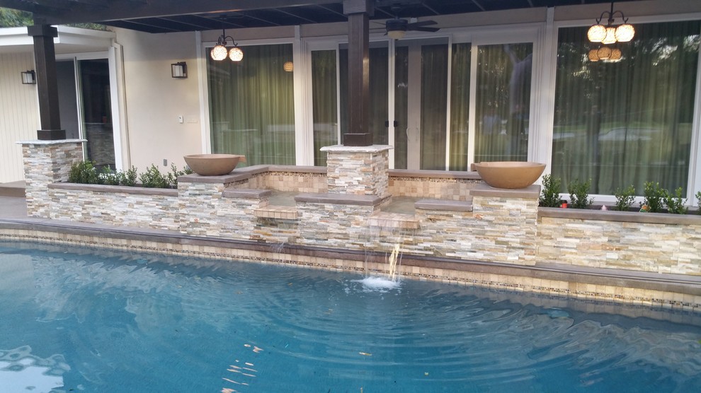 Oberirdischer, Großer, Gefliester Moderner Pool hinter dem Haus in individueller Form mit Wasserspiel in Los Angeles