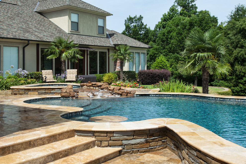Aménagement d'une grande piscine naturelle montagne sur mesure avec des pavés en pierre naturelle et un bain bouillonnant.